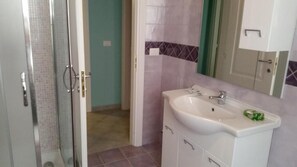 A bathroom with a shower, a sink, and cabinets. - B&B Santantonio (Crecchio)