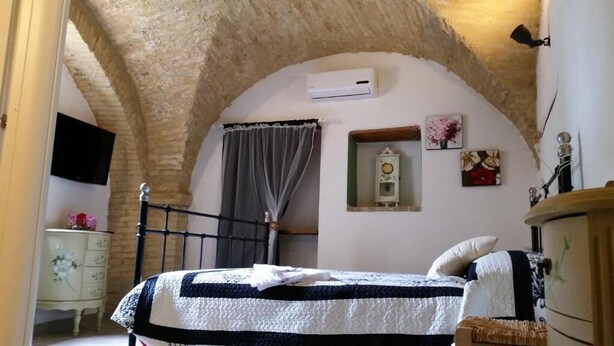 A bedroom with a bed, a dresser, a television, and a clock on the wall. - B&B Santantonio (Crecchio)