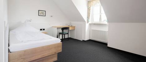 Ein Schlafzimmer mit einem Bett, einem Schreibtisch und einem Stuhl.
