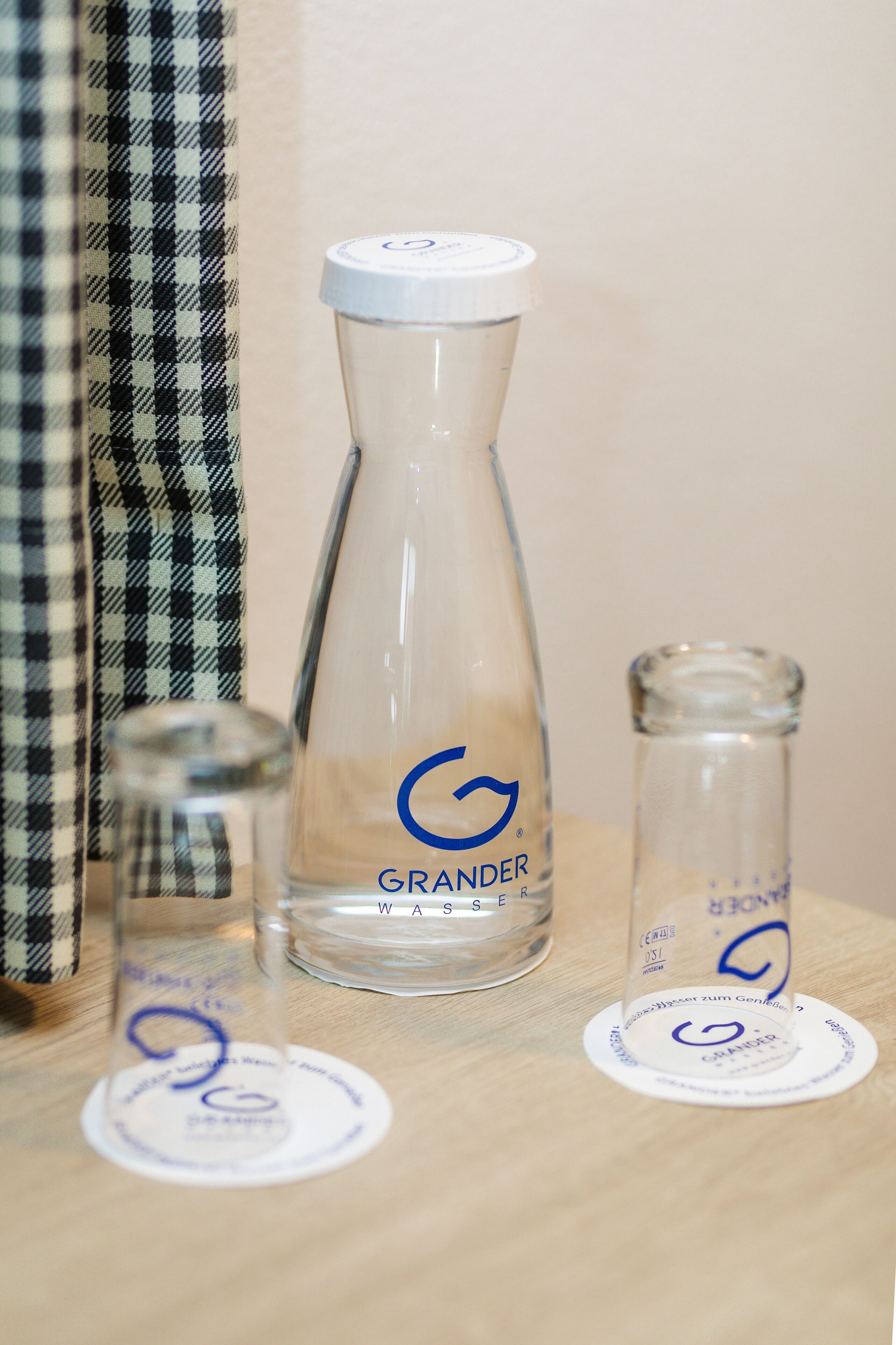 Tres recipientes de vidrio con el logo GRANDER sobre una superficie de madera.