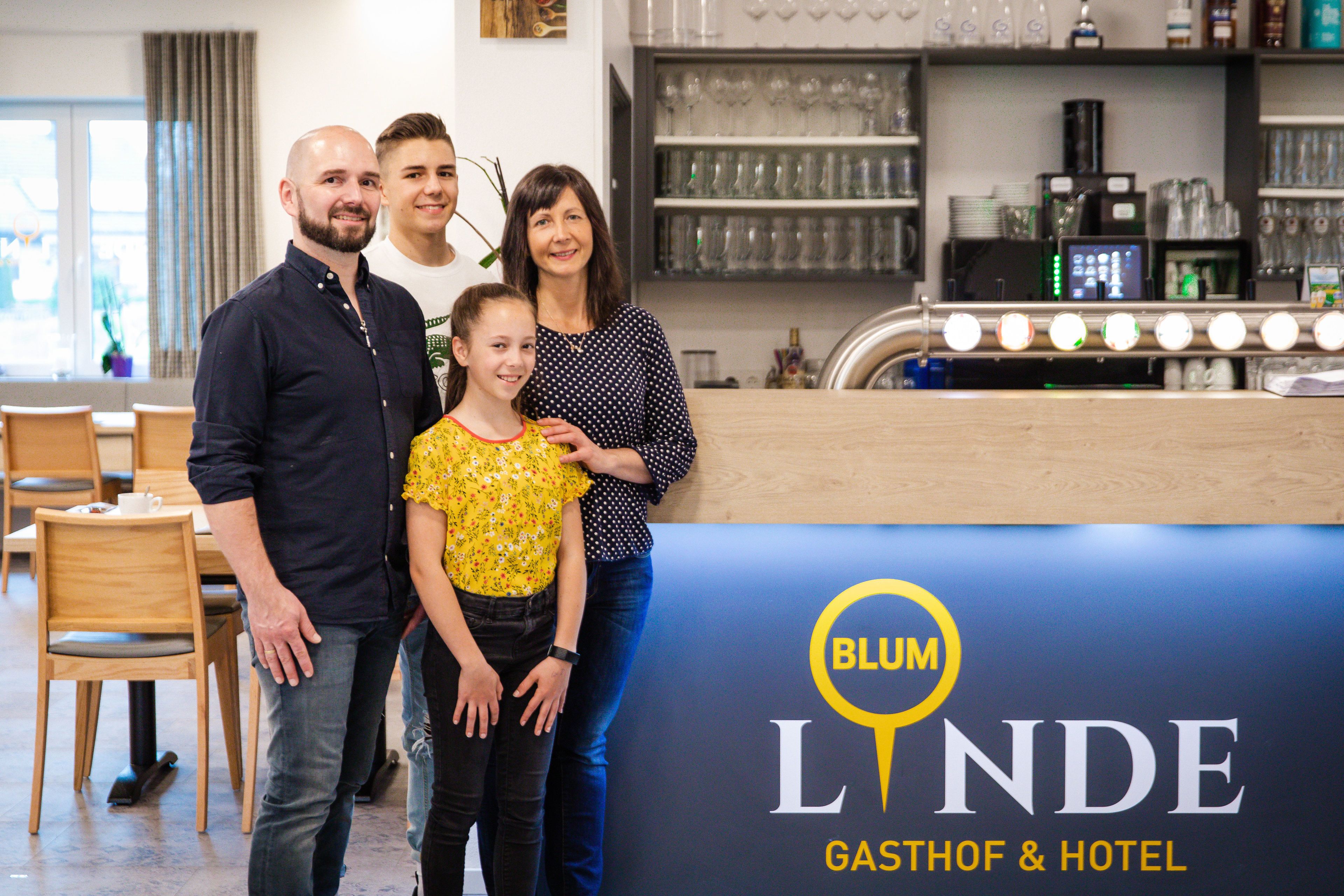 A family posing in front of a hotel sign.