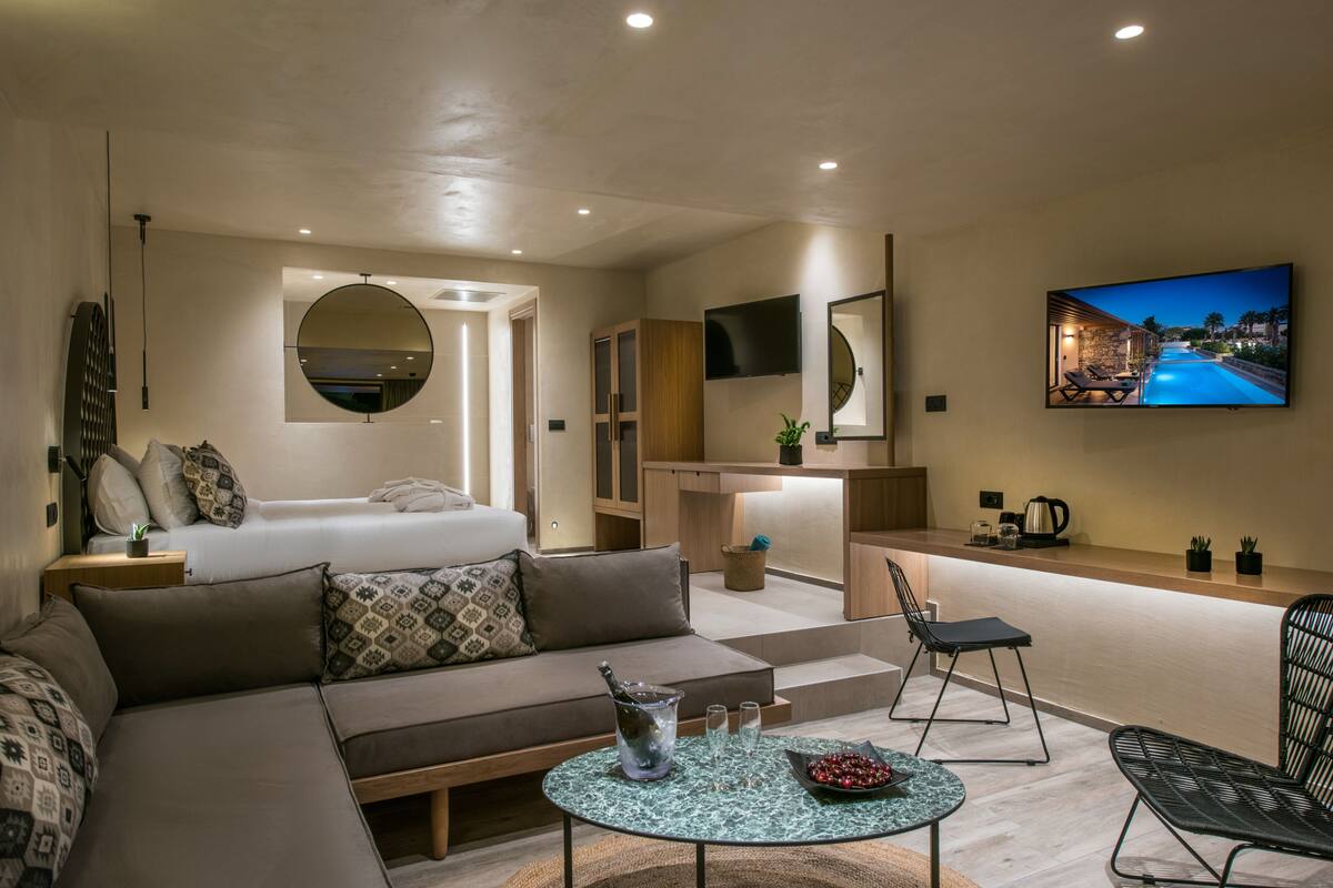 Un salon moderne et bien éclairé, comprenant un canapé, une table basse et un téléviseur fixé au mur.
