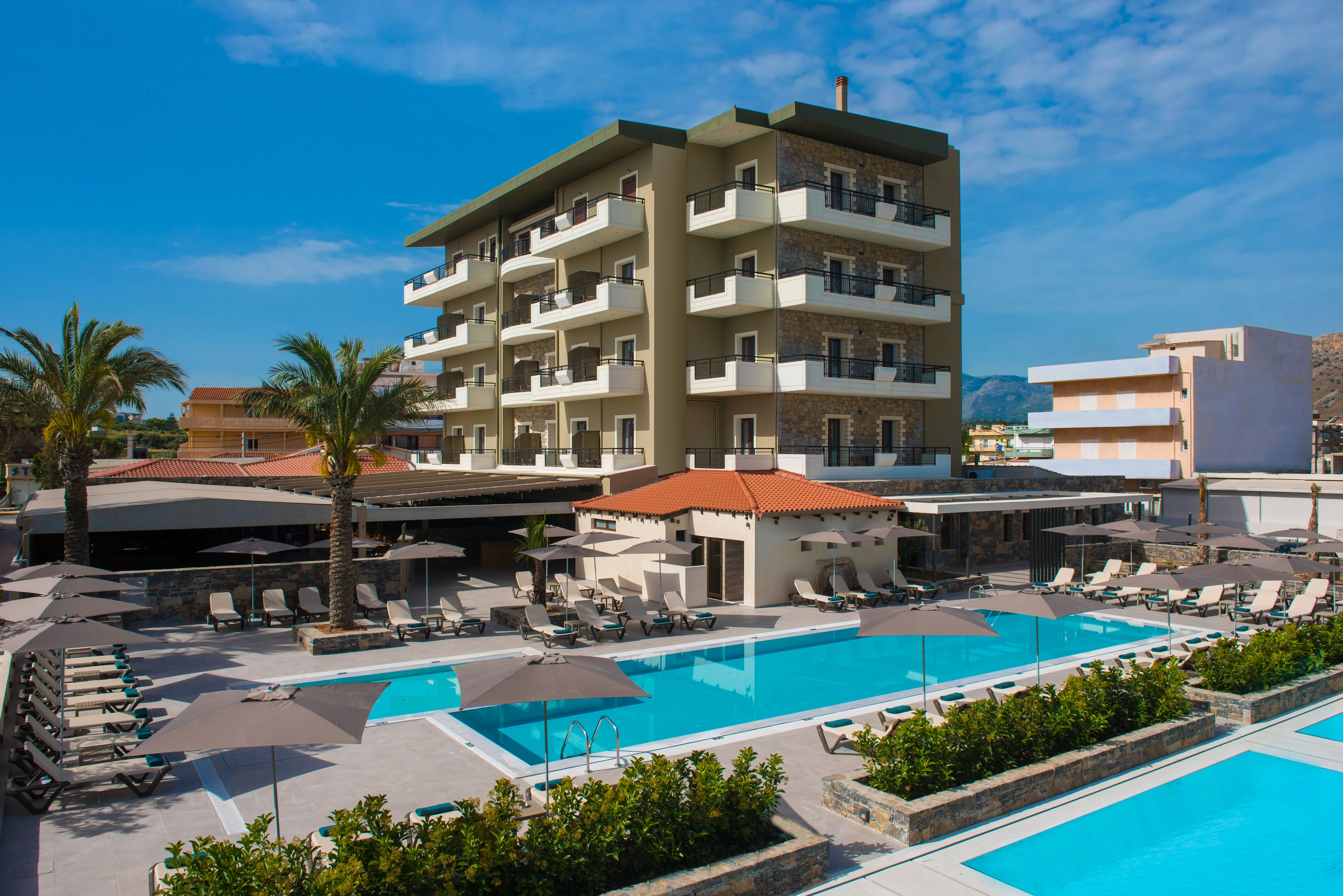 Un hôtel doté de nombreux balcons, d’une piscine et de chaises longues.