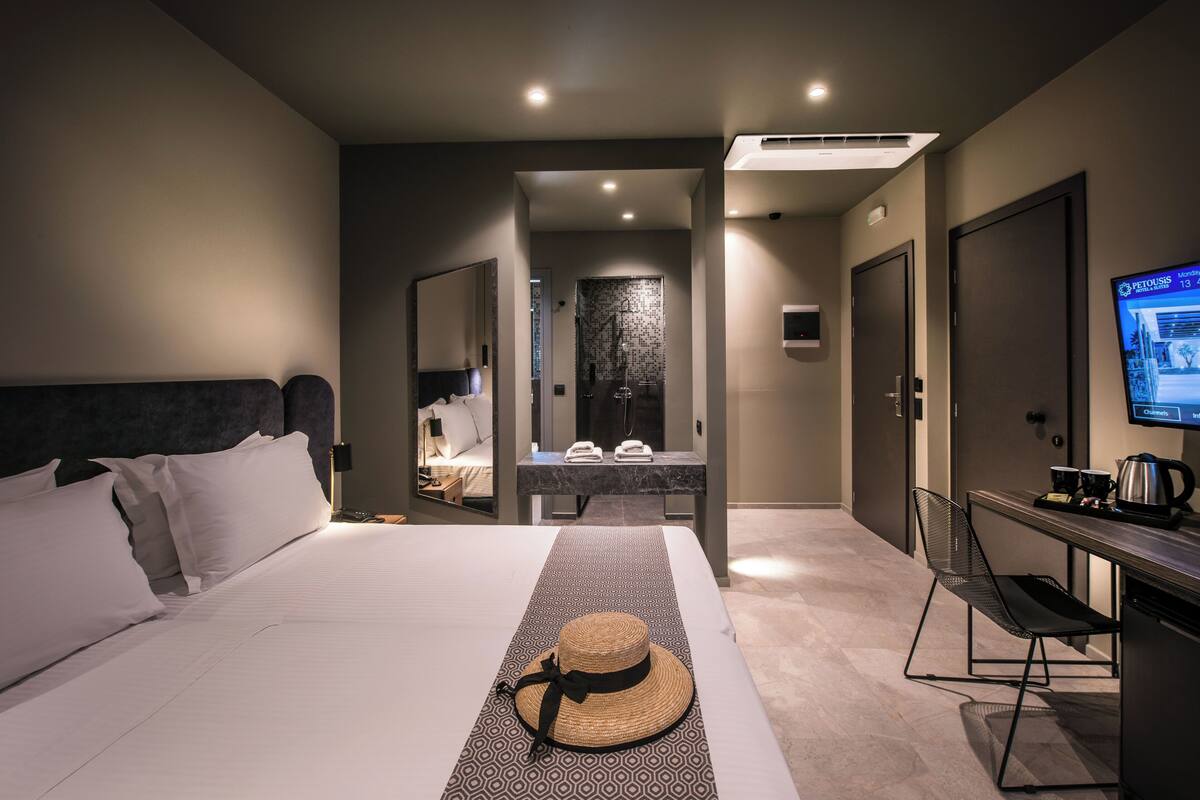 Une chambre d’hôtel moderne avec un grand lit, un bureau équipé d’un ordinateur et une télévision.