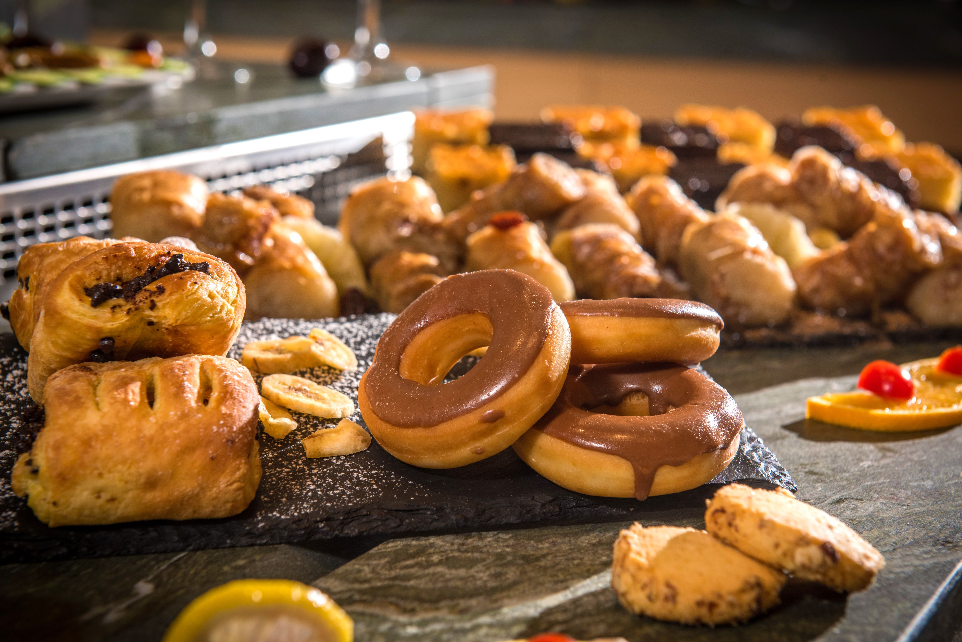 Une variété de pâtisseries et de produits de boulangerie présentés sur une planche en ardoise.