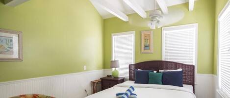 A bedroom with a bed, a nightstand, a lamp, and a chair.