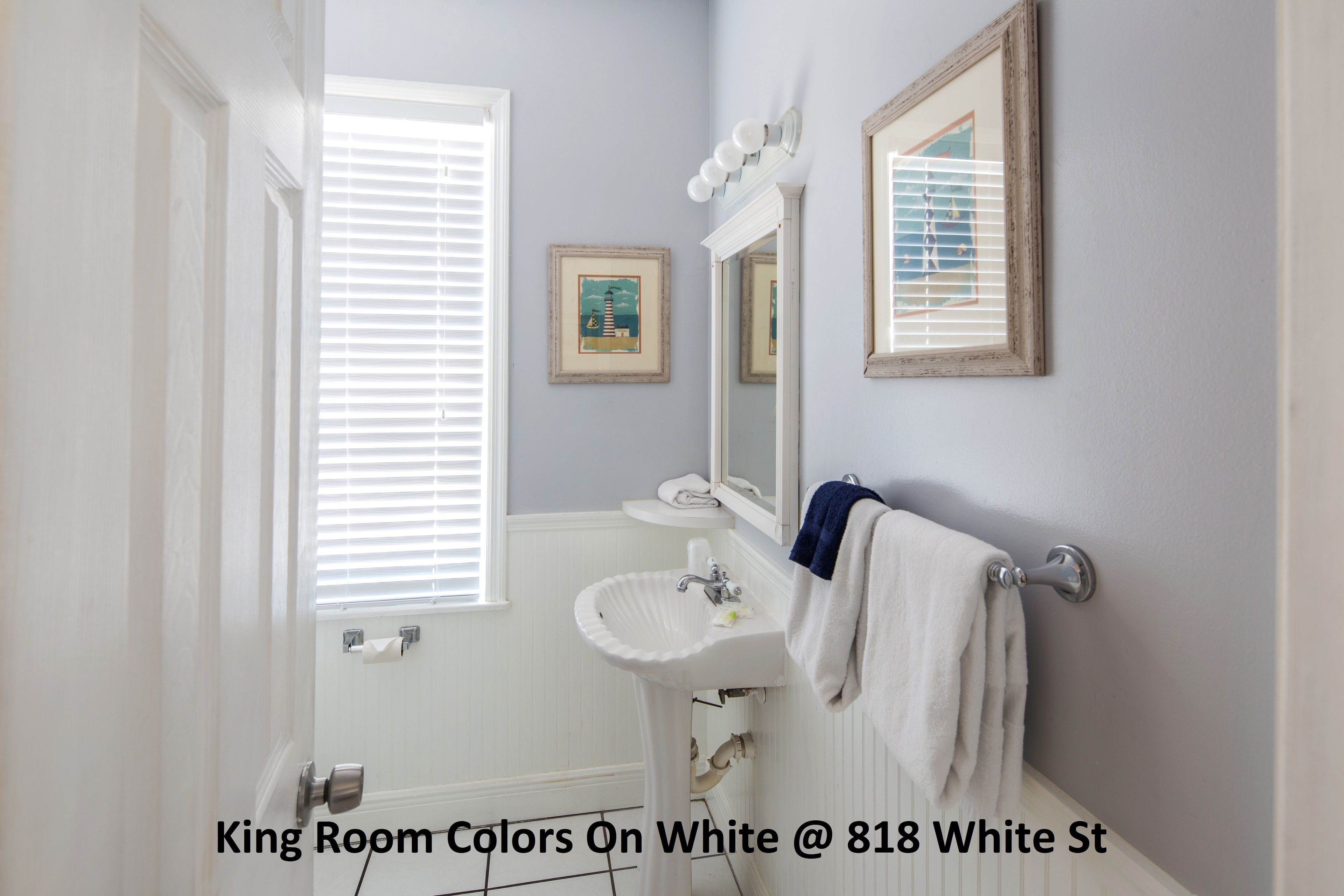 A bathroom with a white sink, a mirror, and a towel rack.