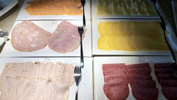 A buffet with various types of deli meats and cheeses.