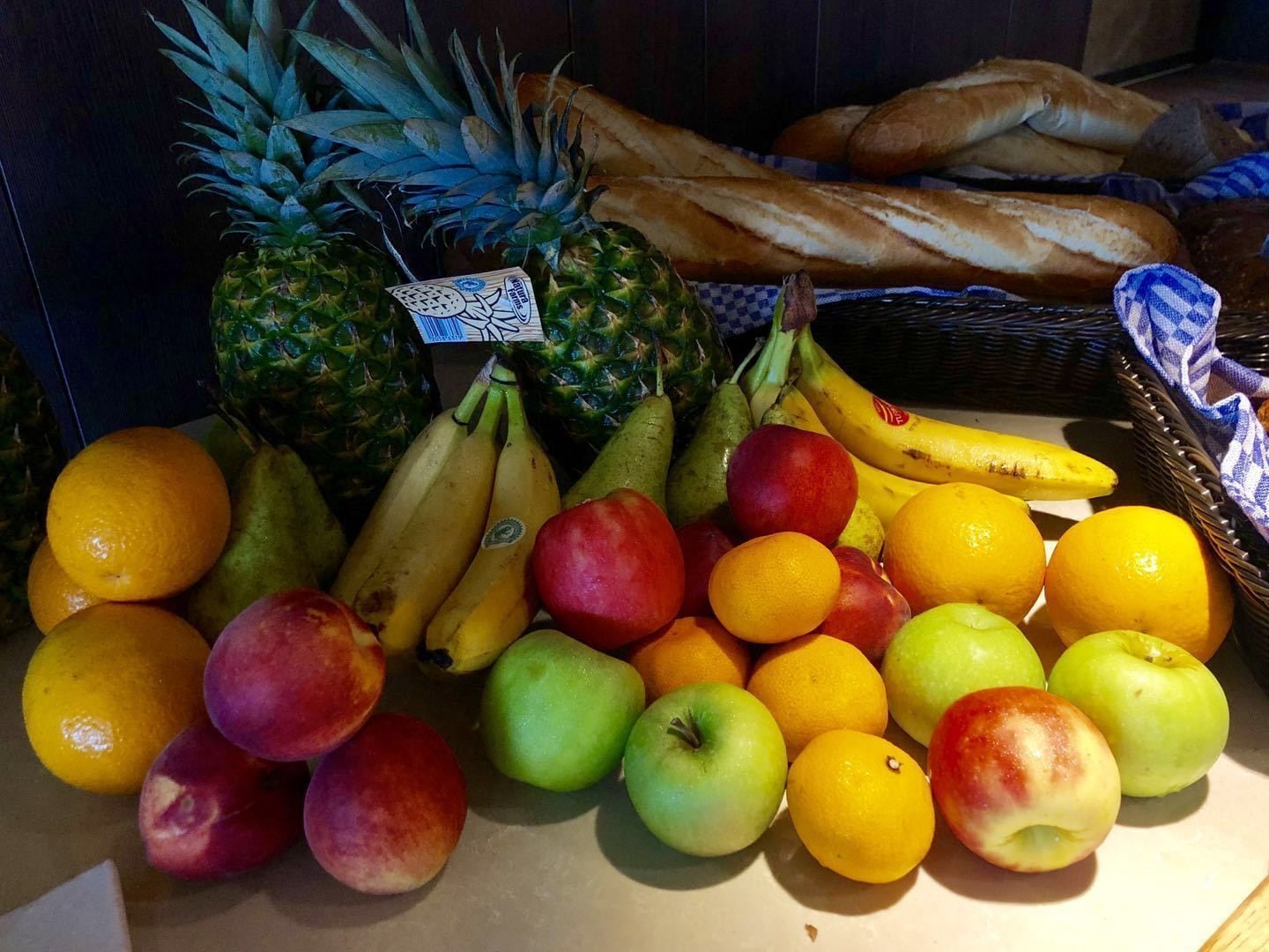 A variety of fruits and bread on a table.