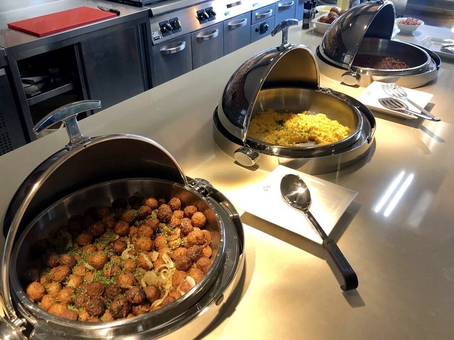 Montaje de bufé con diversos platos, incluyendo albóndigas, arroz y sopa.