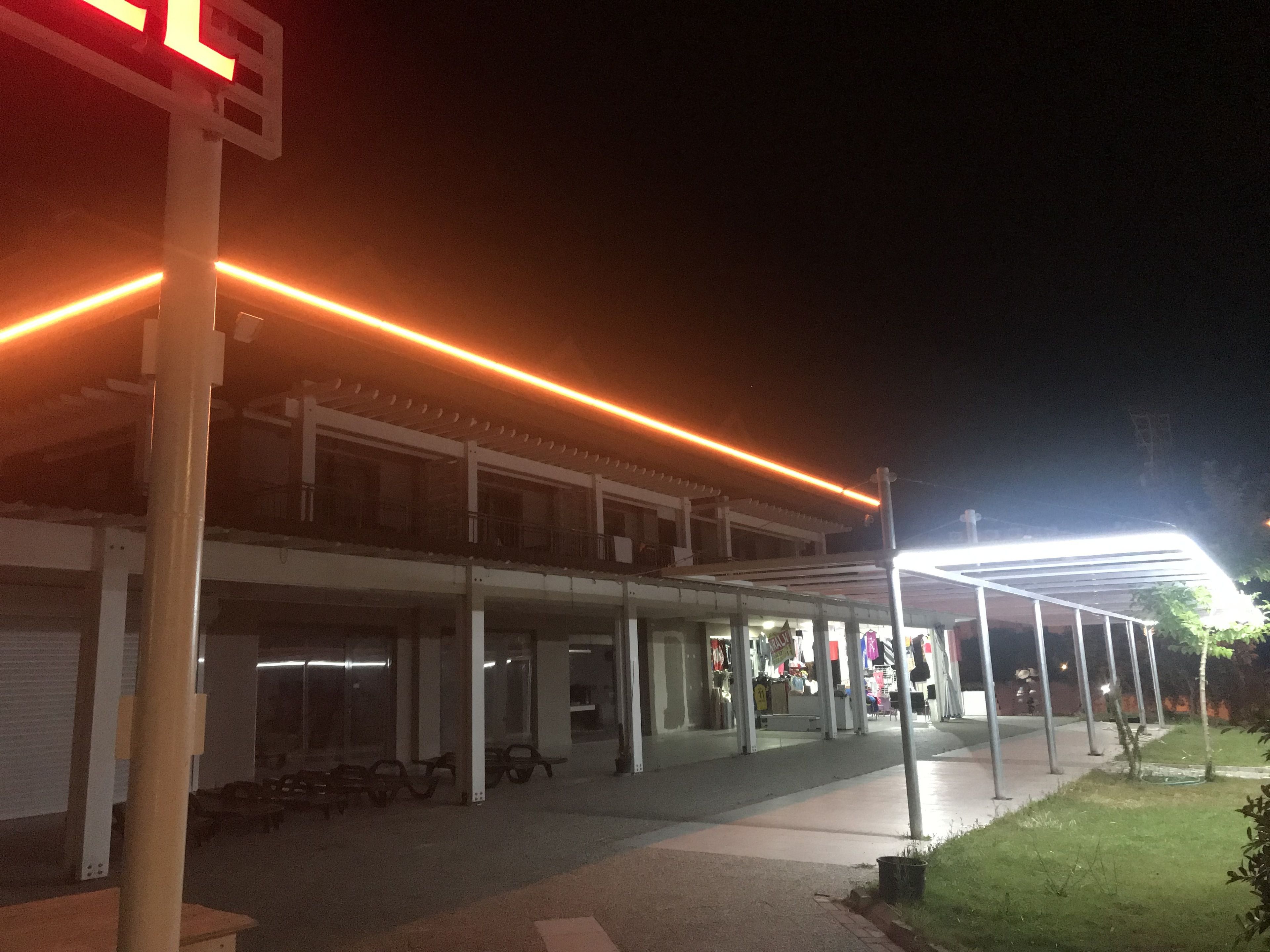 Un edificio con un paseo techado y bancos.