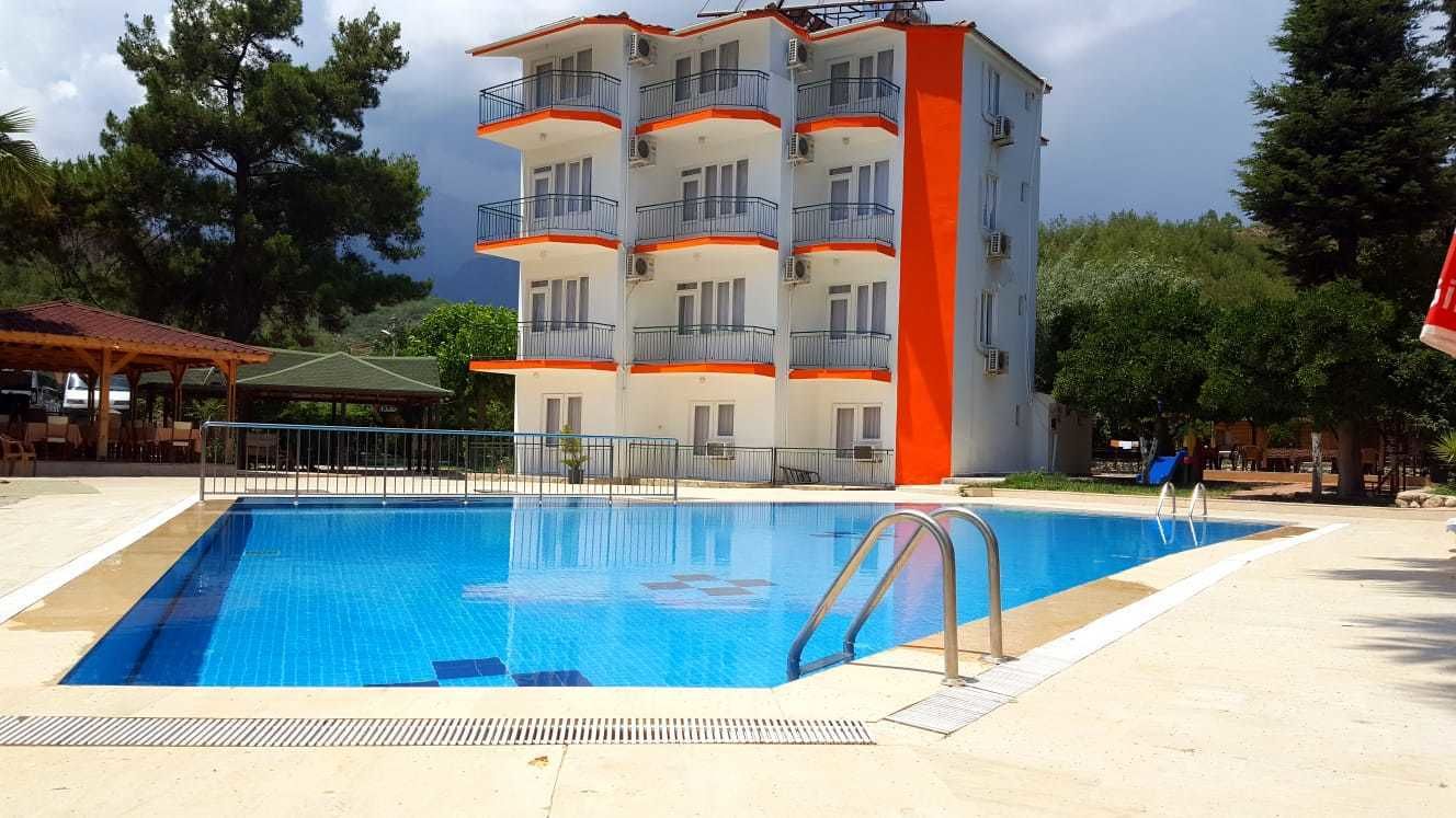 Una piscina con un edificio de varios pisos al fondo.