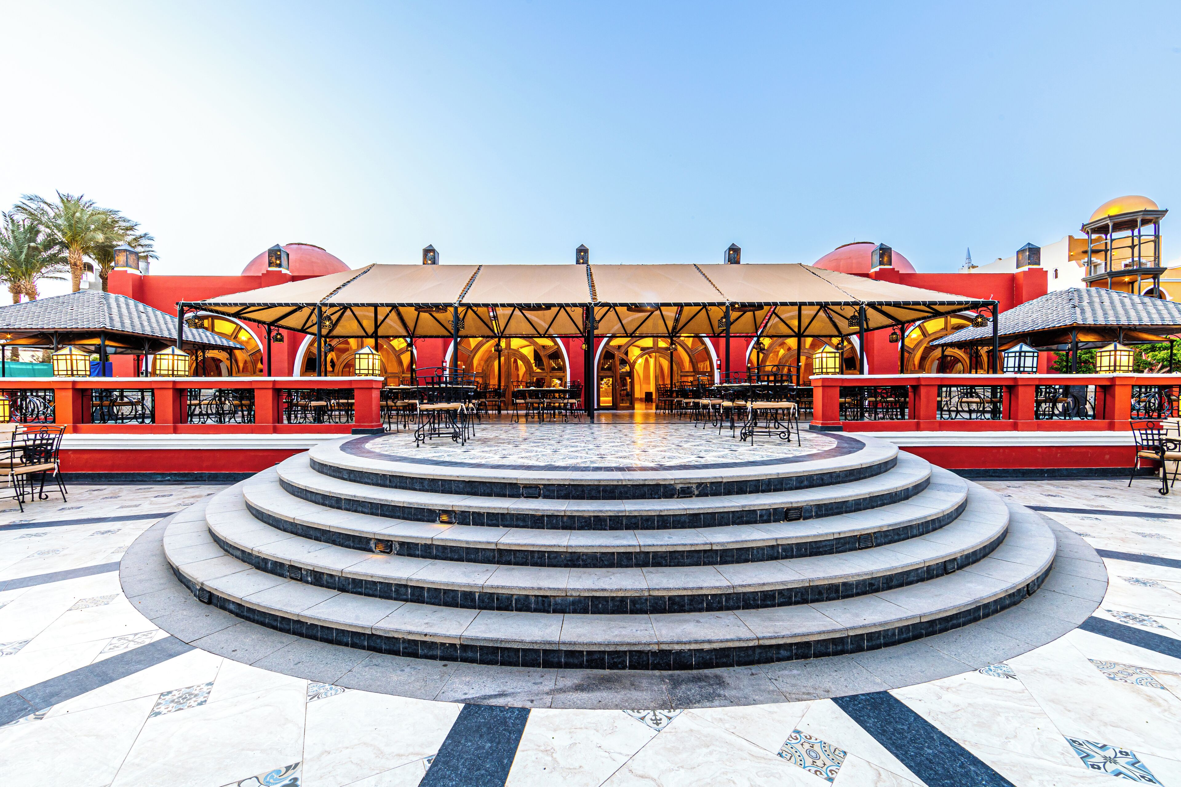 Una plaza pública con una escalera central que conduce a un pabellón al aire libre con zonas de estar.