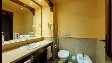 Ein Badezimmer mit Waschbecken, Toilette, Bidet und einem großen Spiegel.