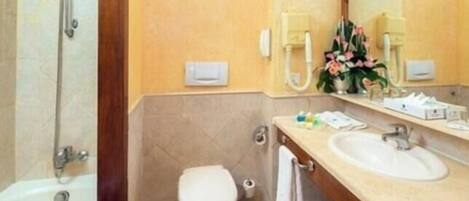 Een badkamer met een bad, toilet, wastafel en een spiegel.