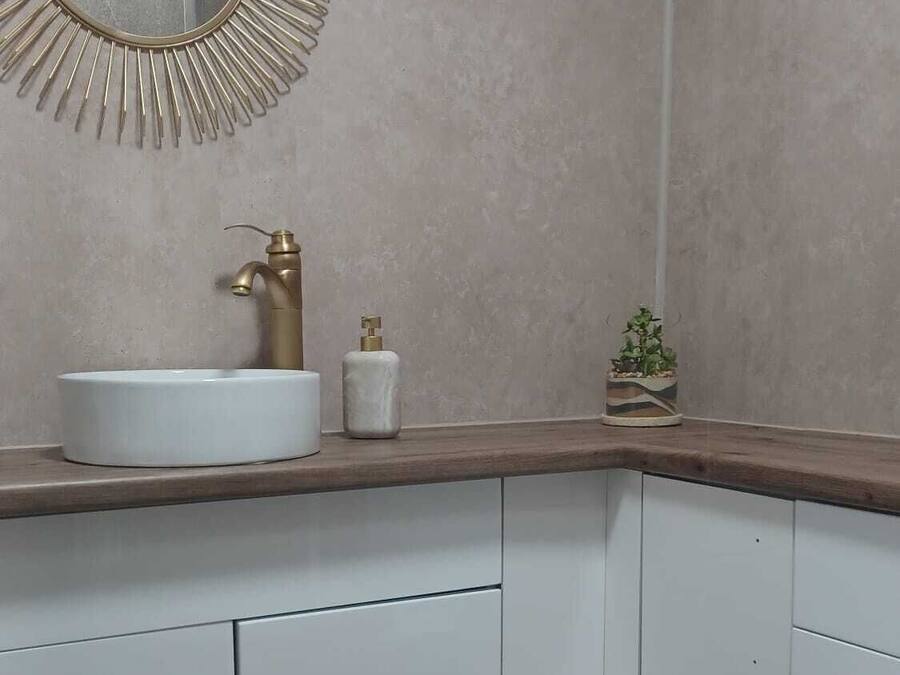 A bathroom with a round mirror, a sink, and a toilet.