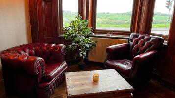 A room with two leather armchairs, a wooden coffee table, and a potted plant.