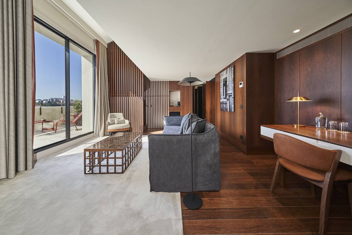 A modern living room with a sofa, coffee table, and a dining area with a chair and table.