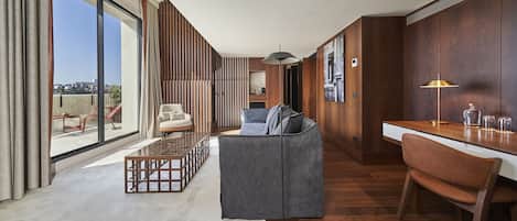 A modern living room with a sofa, coffee table, and a dining area with a chair and table.