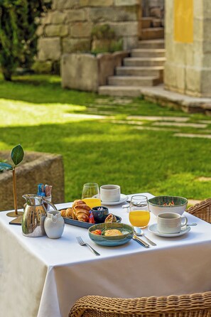 A breakfast table set outdoors with a variety of food items and drinks. - PortoBay Flores (Porto)