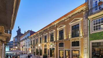 Un edificio histórico con una zona de estar al aire libre cubierta y tiendas en la planta baja.
