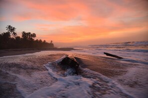 A beach with waves and a sunset. - La Brisa Tranquila - Hostel (Santa Marta)