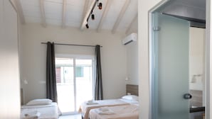 A hotel room with two beds, a sliding glass door to the balcony, and a modern design. - The Barn by CorfuEscapes (Corfu)