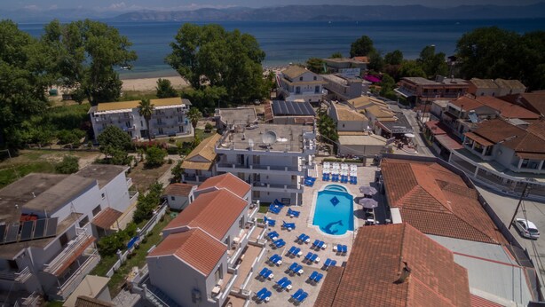 An aerial view of a coastal hotel with a swimming pool, multiple buildings, and a beach in the background. - The Barn by CorfuEscapes (Corfu)