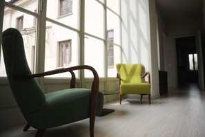 A room with a large window, a green armchair, and a yellow chair. - Oasi di Cavoretto 97 - Casa per Ferie (Turin)