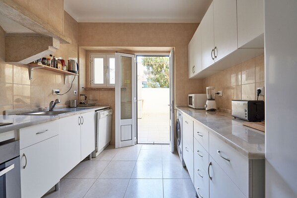 Enjoy cooking in this well-lit kitchen with sleek cabinetry, a stainless steel sink, and microwave.