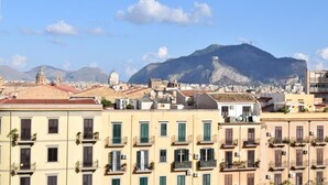 A coastal cityscape with a prominent mountain in the background. - L'Aquilone B&B (Palermo)