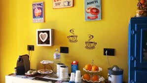 A kitchen counter with coffee-making equipment, a water dispenser, and a fruit display. - L'Aquilone B&B (Palermo)