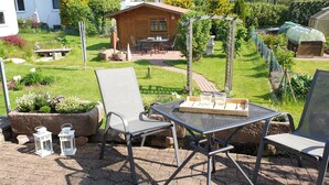 An outdoor patio with two metal chairs, a table, and a lantern. - Modern apartment with terrace in Waldeck - Höringhausen (Höringhausen)