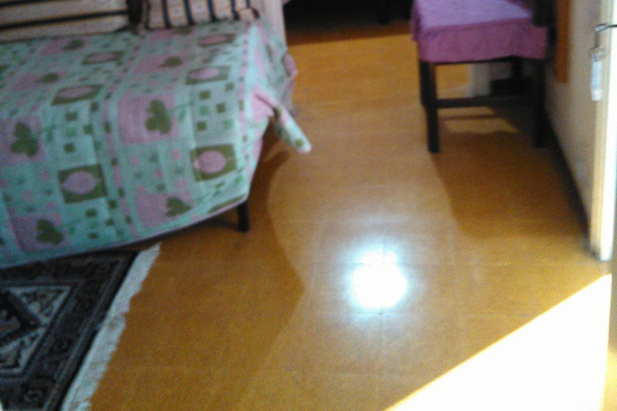 Huoneessa on kaksi sänkyä, tuoli ja pieni pöytä.
