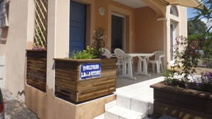 A building with a blue door, a sign reading "LAVARTINE," and outdoor seating with white plastic chairs. - Quiet house in the garrigue, 20 minutes from the beach (6 people) (Béziers)