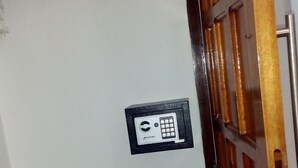 Une pièce avec un banc en bois, une porte dotée d’une poignée en métal et une prise électrique fixée au mur.