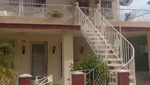 Un bâtiment à deux étages avec un escalier menant à un balcon.