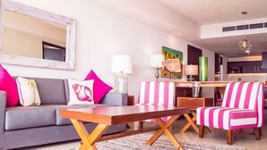 A modern living room with a grey sofa, a wooden coffee table, and a striped armchair. - WINTER OFFER!! CHIC & MODERN BEACHFRONT CONDO W/TERRACE (Puerto Vallarta)