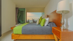 A modern hotel room with a bed, a nightstand, a lamp, and a view of a building through a window. - WINTER OFFER!! CHIC & MODERN BEACHFRONT CONDO W/TERRACE (Puerto Vallarta)