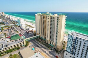 Ein Hochhaus-Hotel mit mehreren Etagen, einer Tiefgarage und Blick auf Strand und Meer.