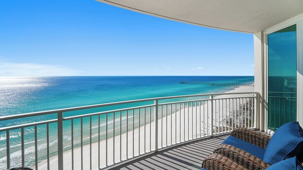 A balcony with a view of a beach and ocean.