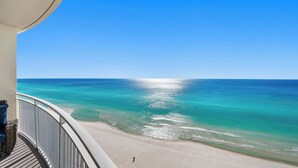A balcony with a view of a beach and ocean.