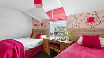 Un dormitorio con dos camas, un escritorio y una ventana con vistas.