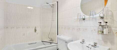 Un baño moderno con bañera, inodoro y lavamanos.