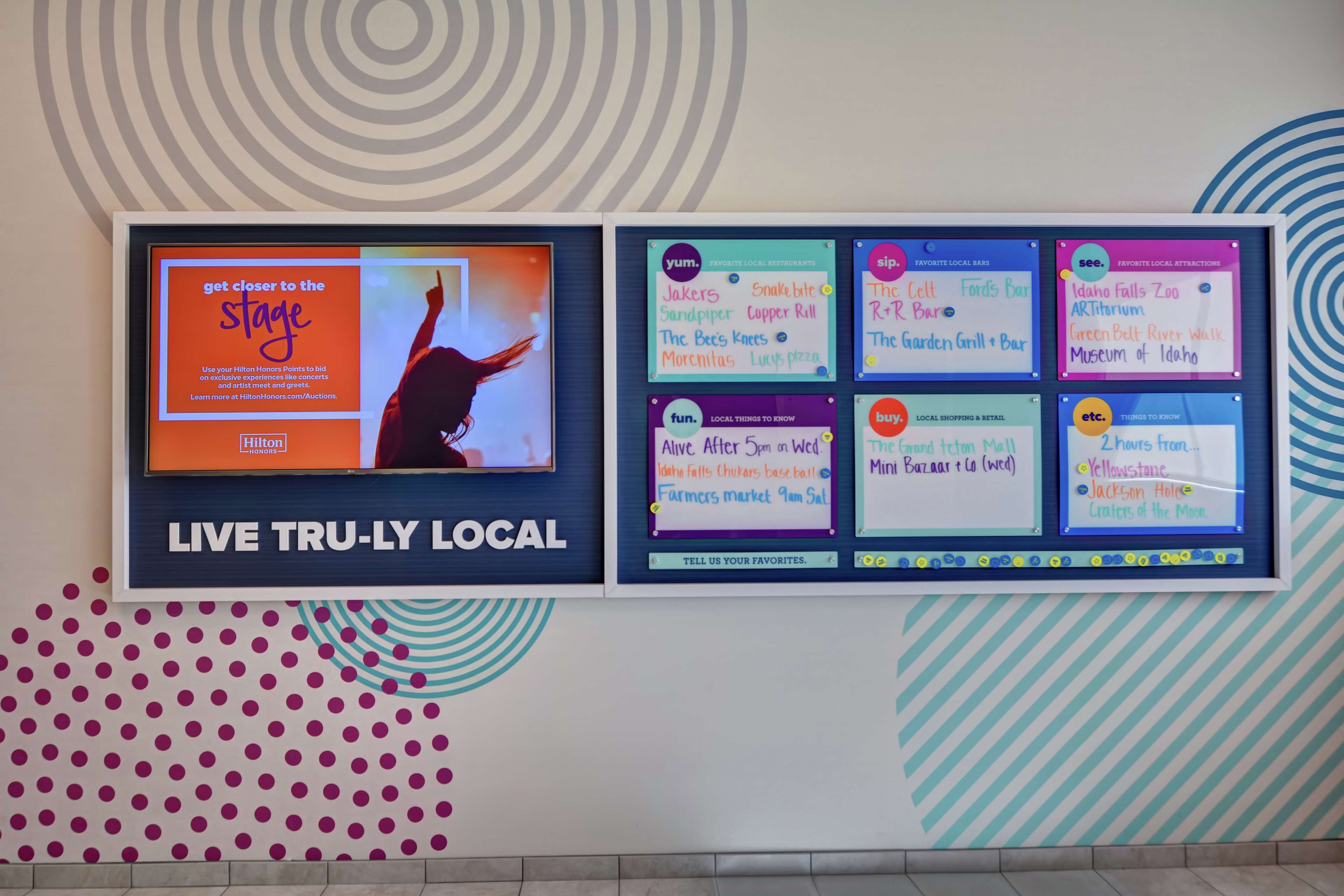 Una pared con diferentes carteles anunciando atracciones locales, restaurantes y zonas comerciales.
