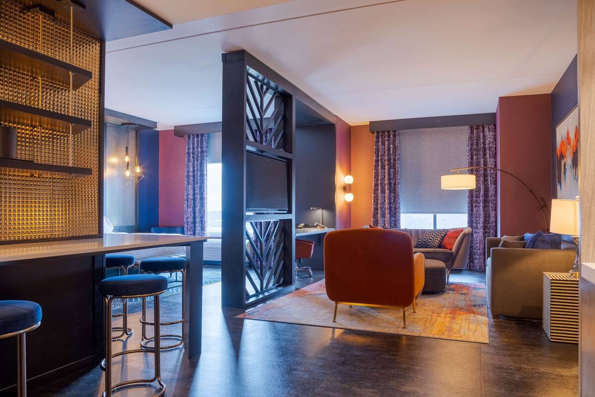 Eine moderne Hotelhalle mit Barbereich, Sitzgelegenheiten und Blick ins Freie.