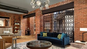A living room with a blue sofa, a round coffee table, and a patterned rug. - The Wilbur Lititz, Tapestry Collection by Hilton (Lititz)