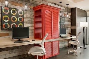 Un espacio de oficina moderno con dos escritorios, cada uno con una computadora y teclado, y sillas ergonómicas.