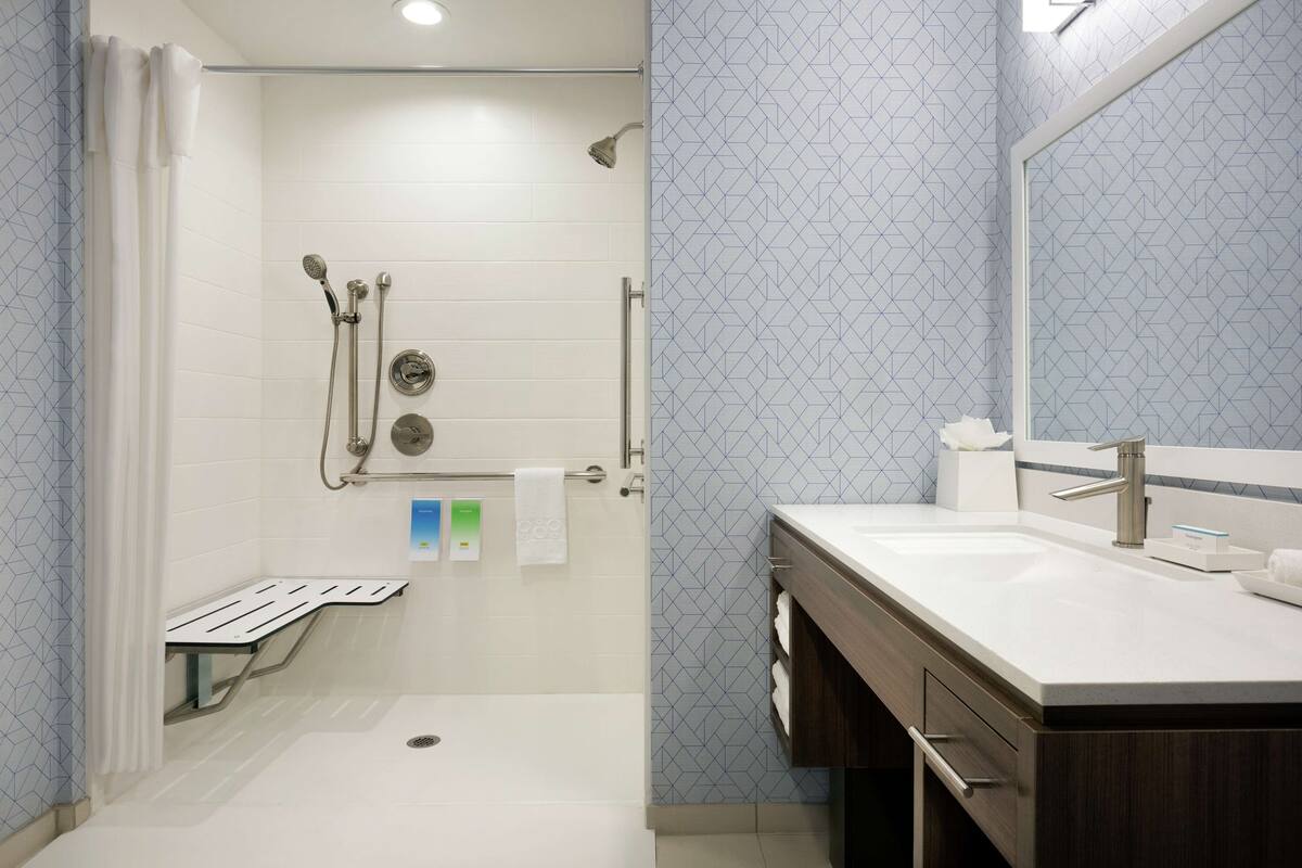 A modern bathroom with a shower, toilet, and sink.