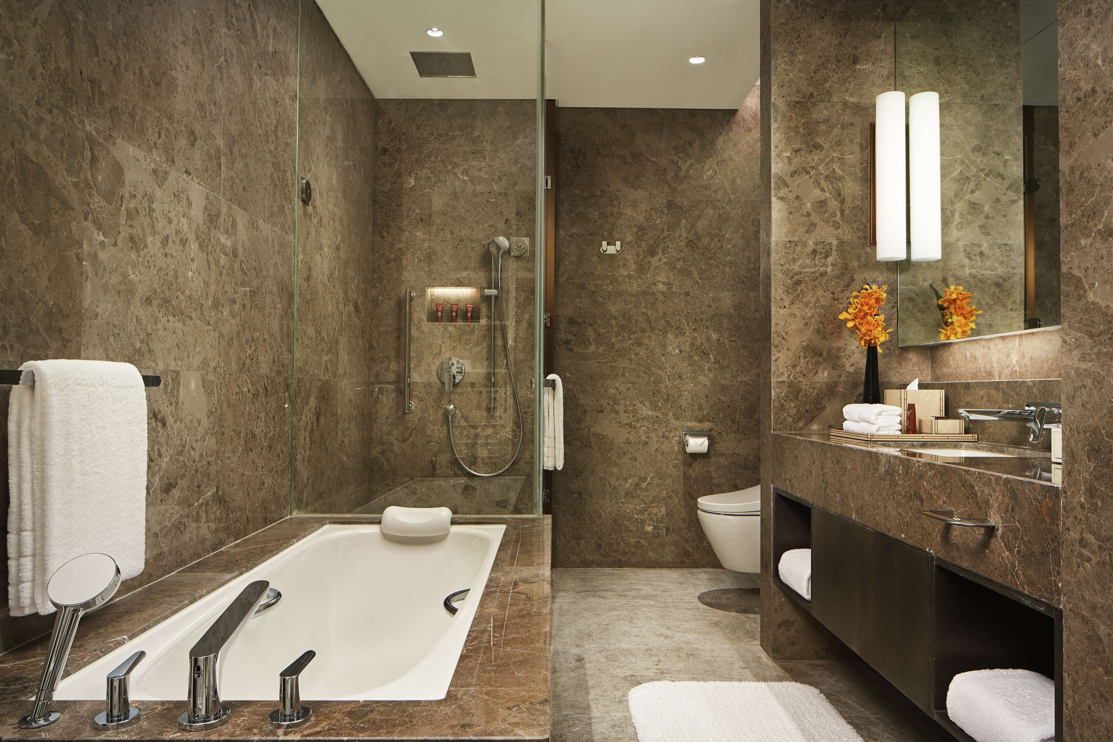 Un baño moderno con una bañera grande, una zona de ducha separada y un tocador con espejo.